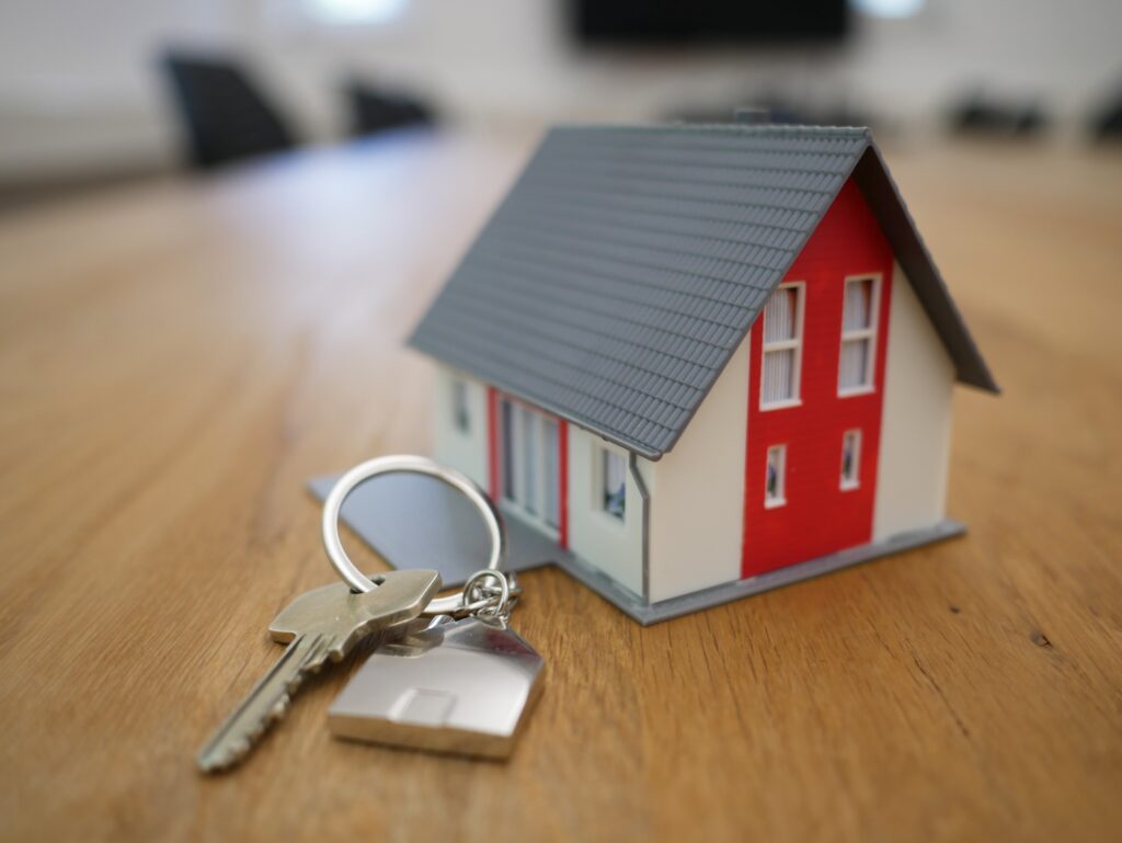 Keys with a small toy house next to them